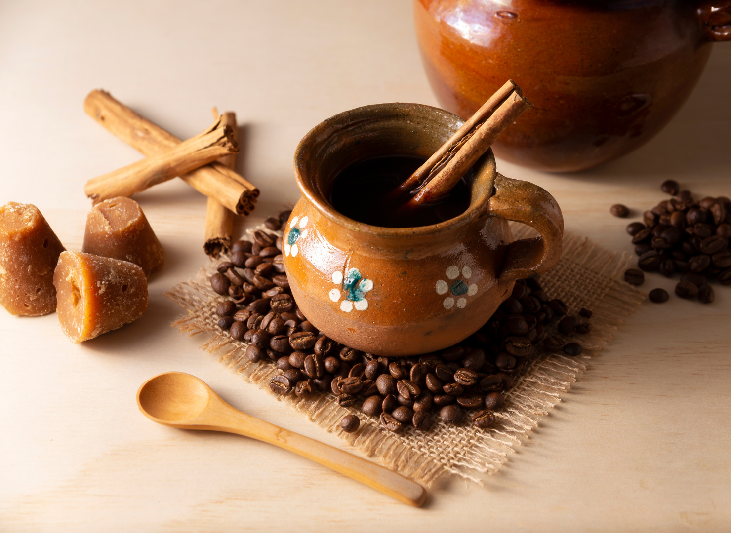 En  brun kop på et bord med kaffebønner rundt om