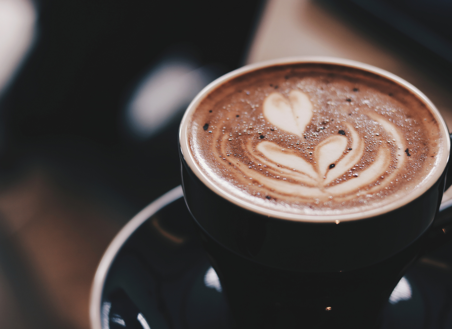 En kop kaffe med mælk på et bord.